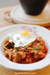 Spanish pisto manchego with fried egg on a plate.