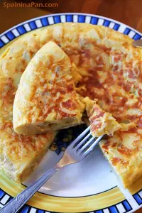 Spanish potato tortilla with onion on a decorative plate.