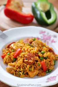 Spanish chicken and chorizo paella on a decorative plate.