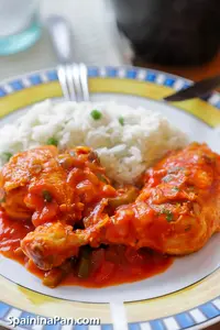 Spanish pollo al chilindron chicken with white rice o a plate.