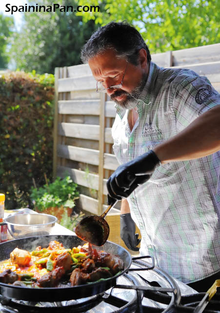 Edu cooking authentic paella Valenciana outside in the garden.