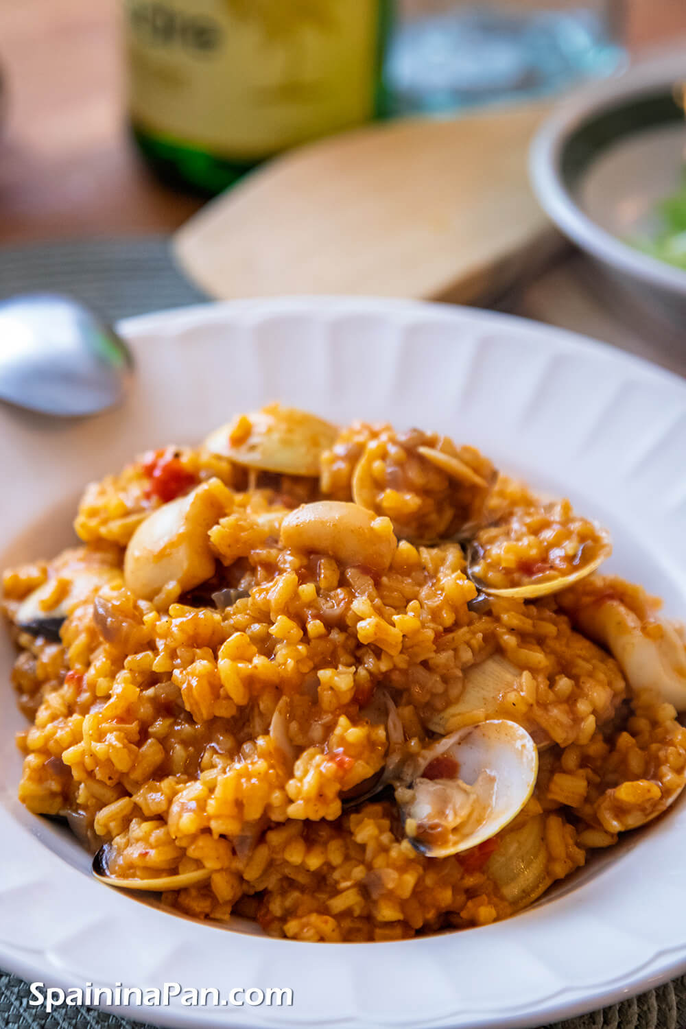 Creamy Spanish rice and venus clams on a plate.