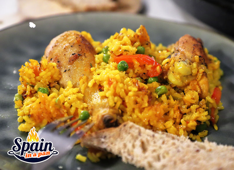 Chicken paella on a gray plate.