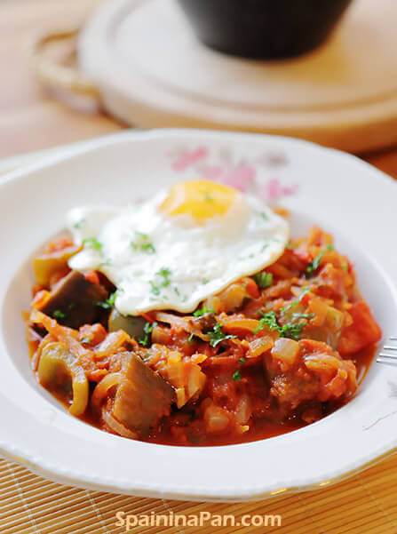 Spanish pisto manchego with fried egg on a plate.