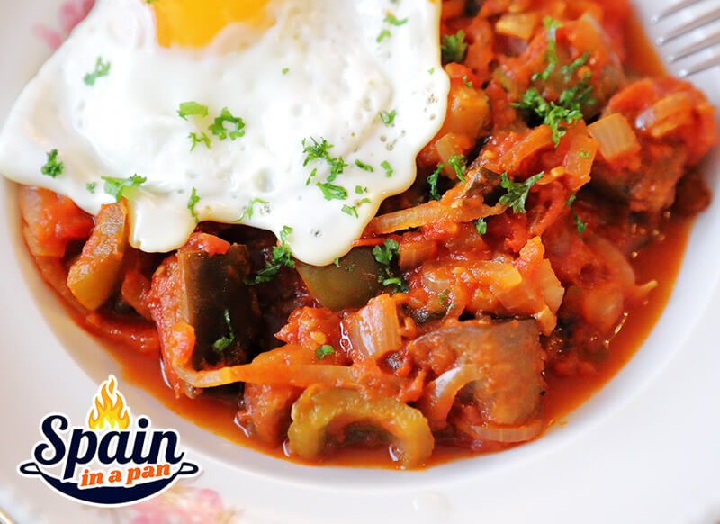 Spanish pisto manchego with fried egg on a plate.