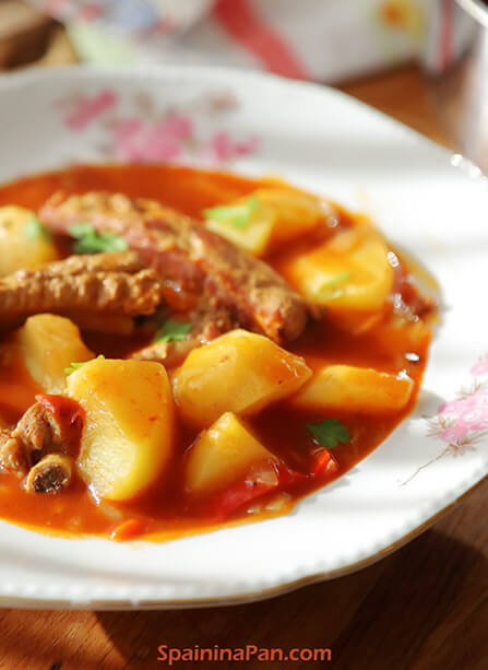 A Spanish potato and ribs stew on a plate.