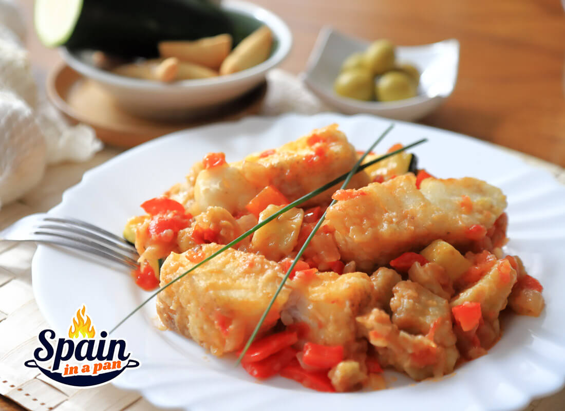 Cod with samfaina sauce on a white plate.