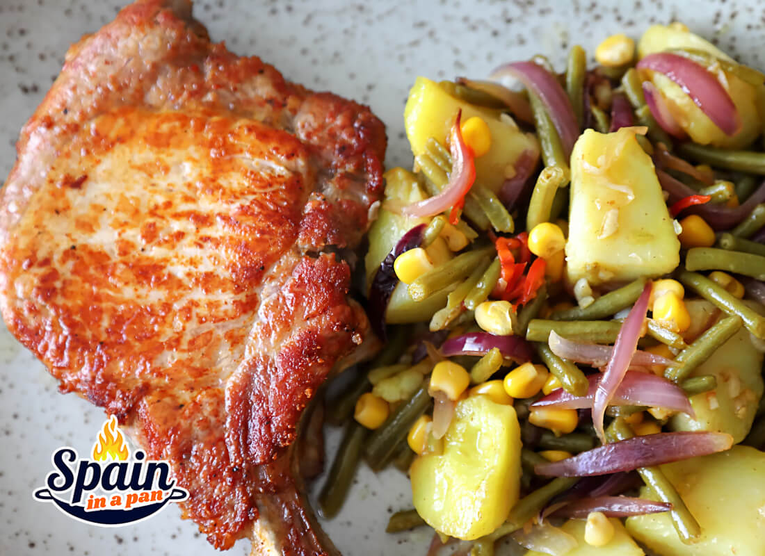 Pork chop with vegetables stir-fry on a rustic plate.