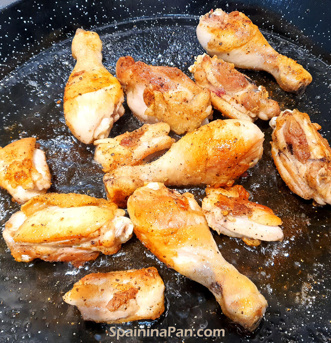 Chicken pieces frying in a pan to make chicken paella.