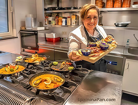 Isabel presenting a dish of mixed tapas in her professional kitchen. Isabel presenting a dish of mixed tapas in her professional kitchen.