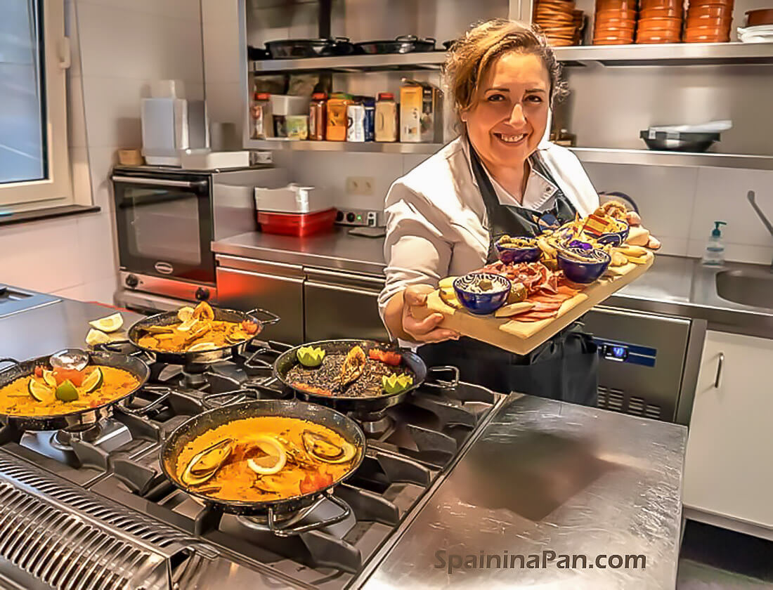 Isabel presenting a dish of mixed tapas in her professional kitchen. Isabel presenting a dish of mixed tapas in her professional kitchen.
