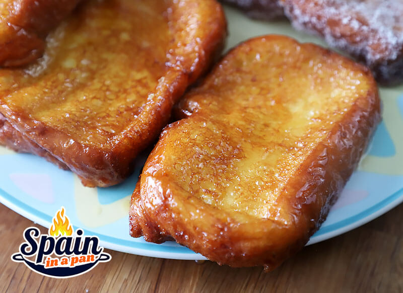 Spanish honey torrijas on a decorative serving plate.