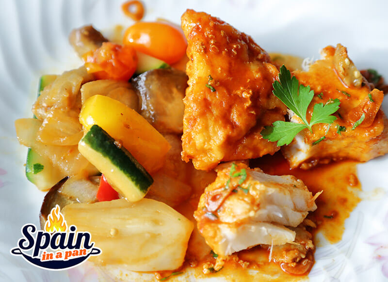 Spanish Bacalao a la llauna with grilled vegetables on a plate.