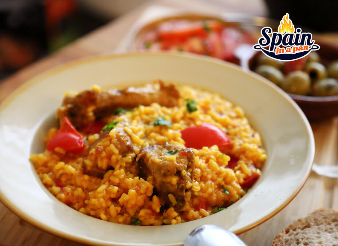 Creamy Spanish rice with pork ribs on a decorative plate.