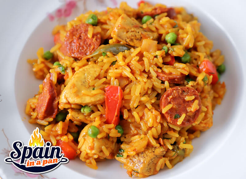 Spanish chicken and chorizo paella on a white plate.
