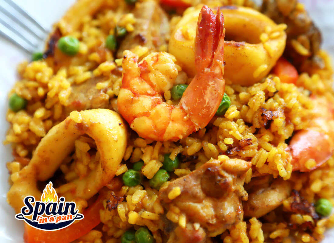 Appetizing paella mixta on a plate looked from above.