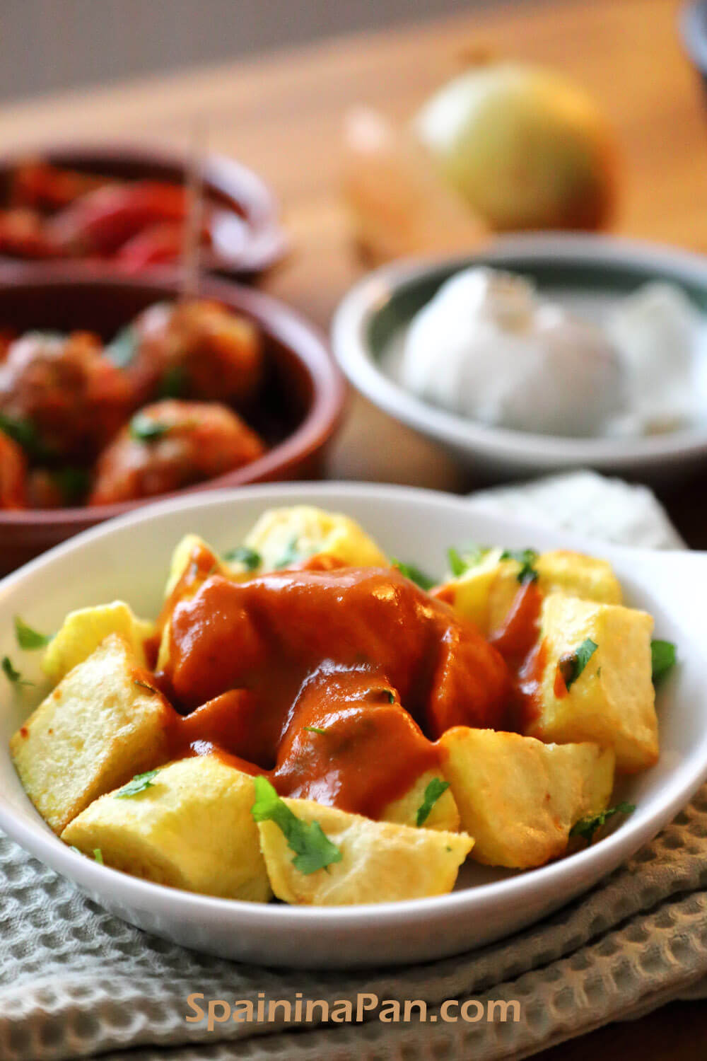 Patatas bravas without tomato in a white tray.