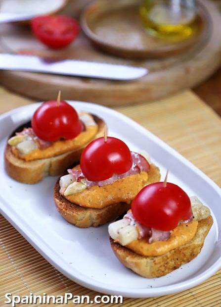 Romesco asparagus pintxos on a ceramic tray.