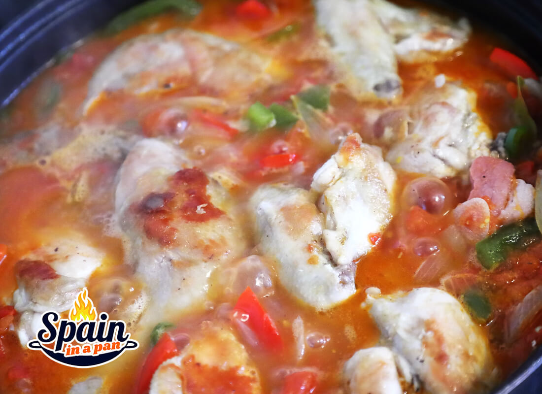 Spanish chicken chilindron simmering in a pan.