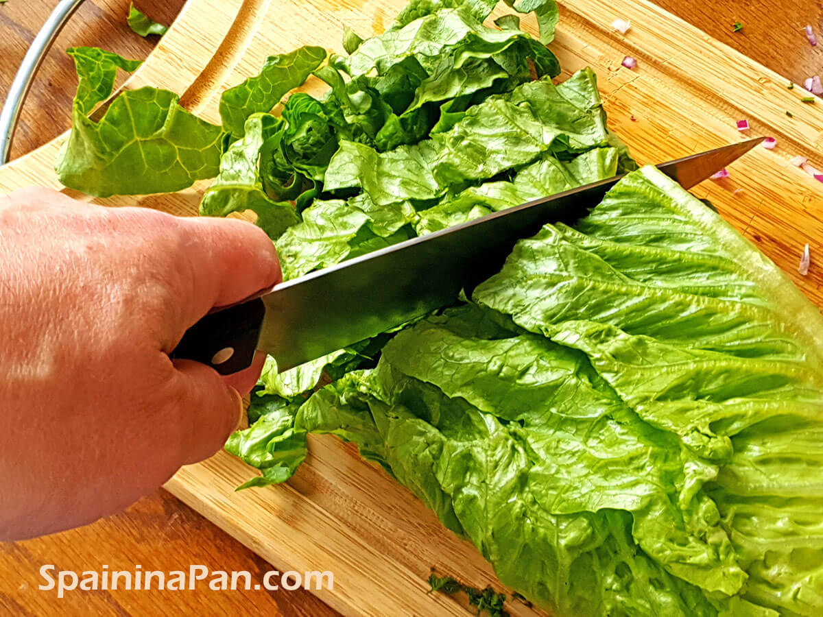Cutting romain lettuce on a chopping board Cutting romain lettuce on a chopping board