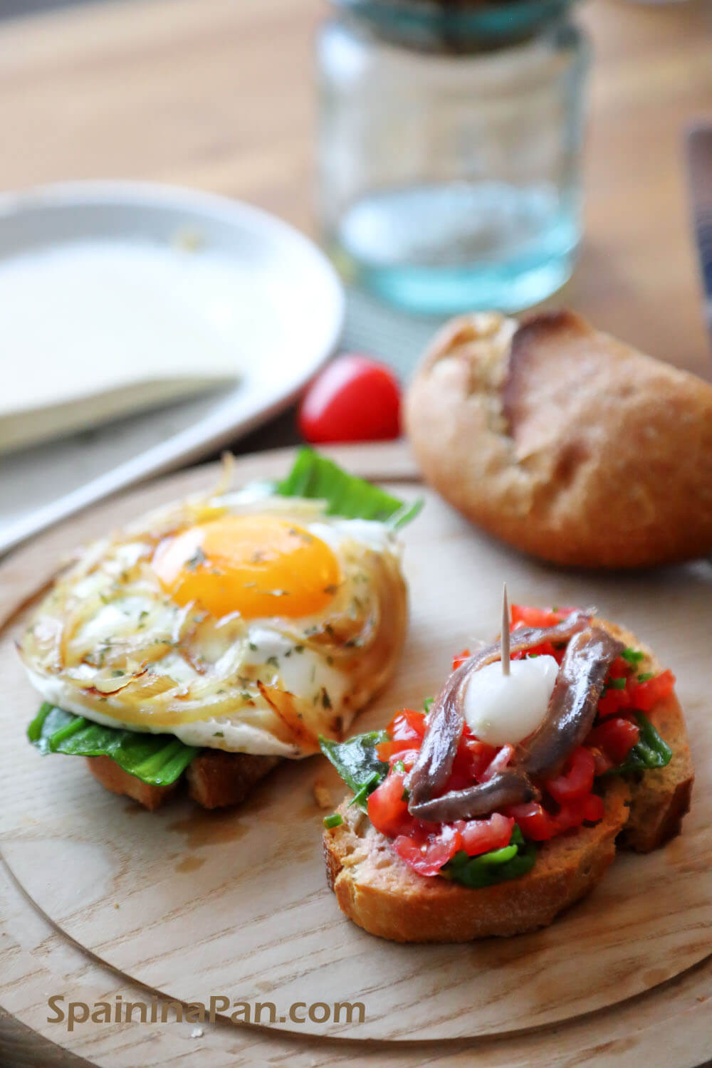 Spanish egg and anchovy pinchos on a wooden tray.