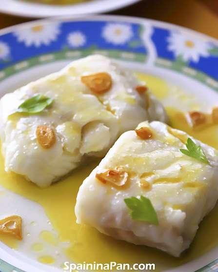 Spanish cod with pil pil sauce on a dish with a glass of beer.