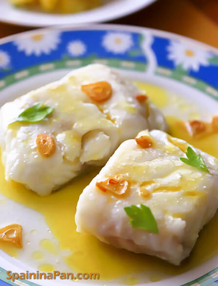 Spanish cod with pil pil sauce on a dish with a glass of beer.