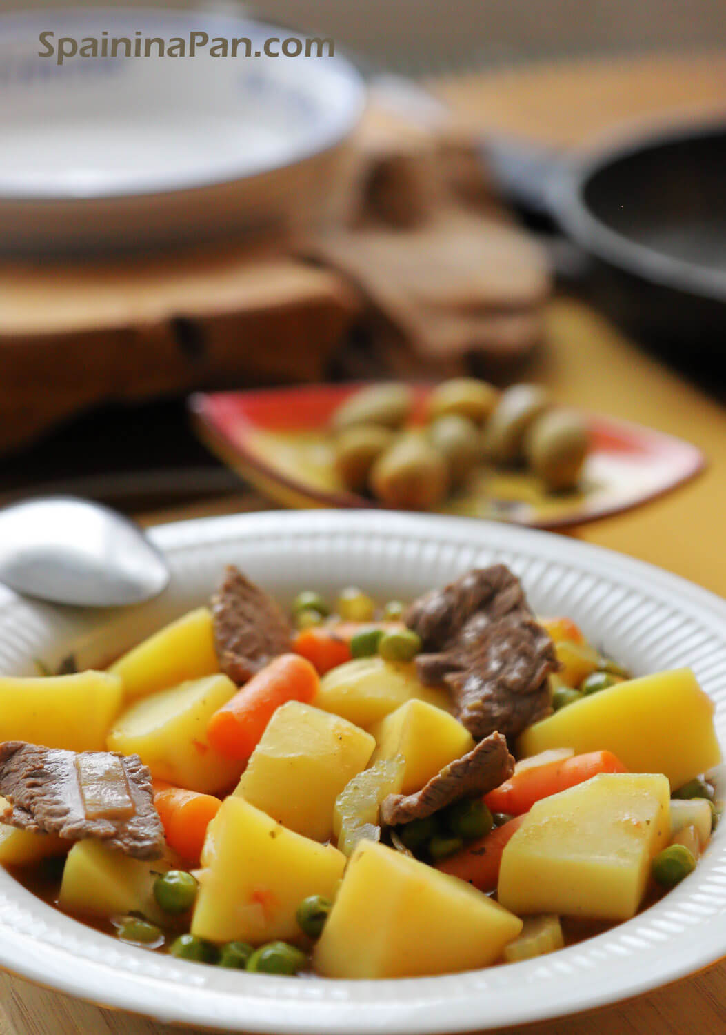 Spanish beef stew with potatoes on plate.