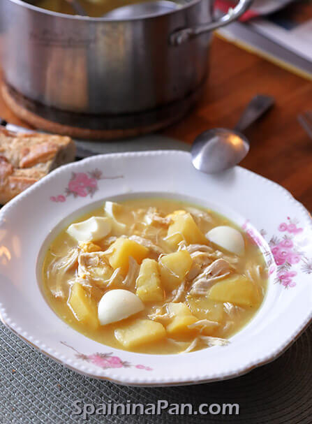 Spanish chicken and eggs soup in a plate with bread.