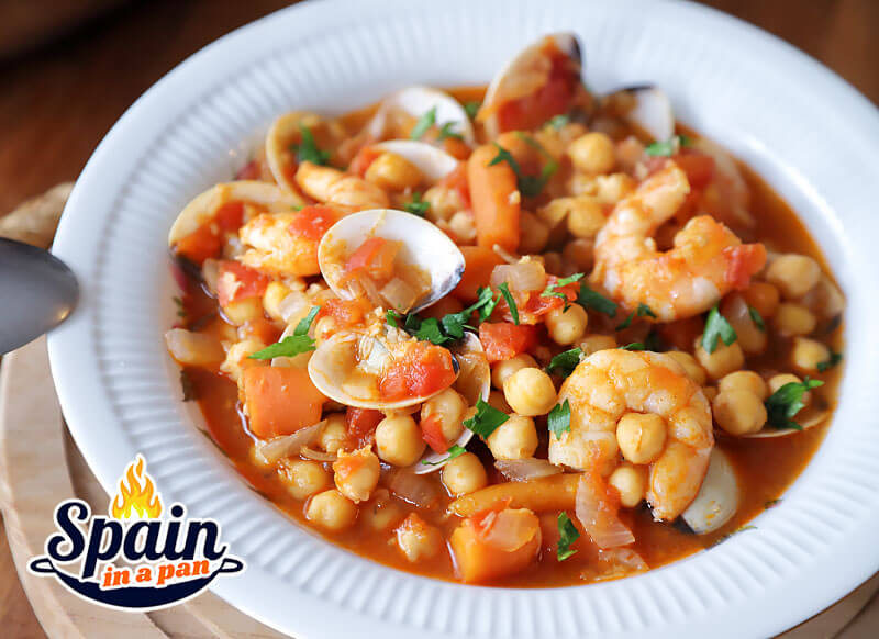 Spanish chickpea and seafood stew on a plate.
