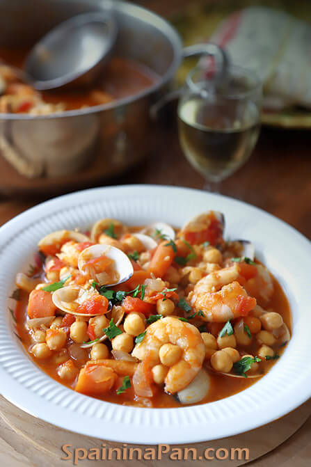 Spanish chickpea and seafood stew on a plate.