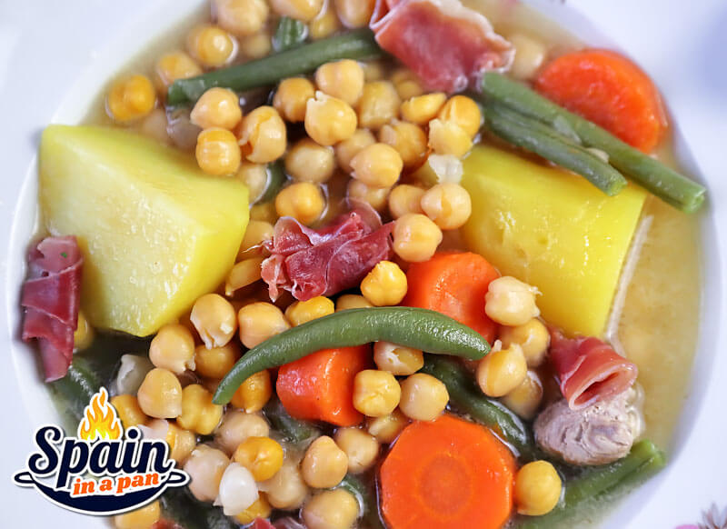 Andalusian cocido stew in a decorative plate with sides.
