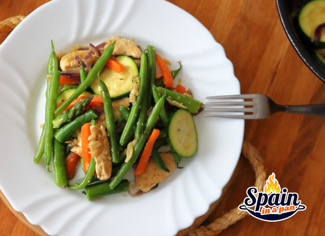 Spanish green beans and chicken stir-fry on a plate.