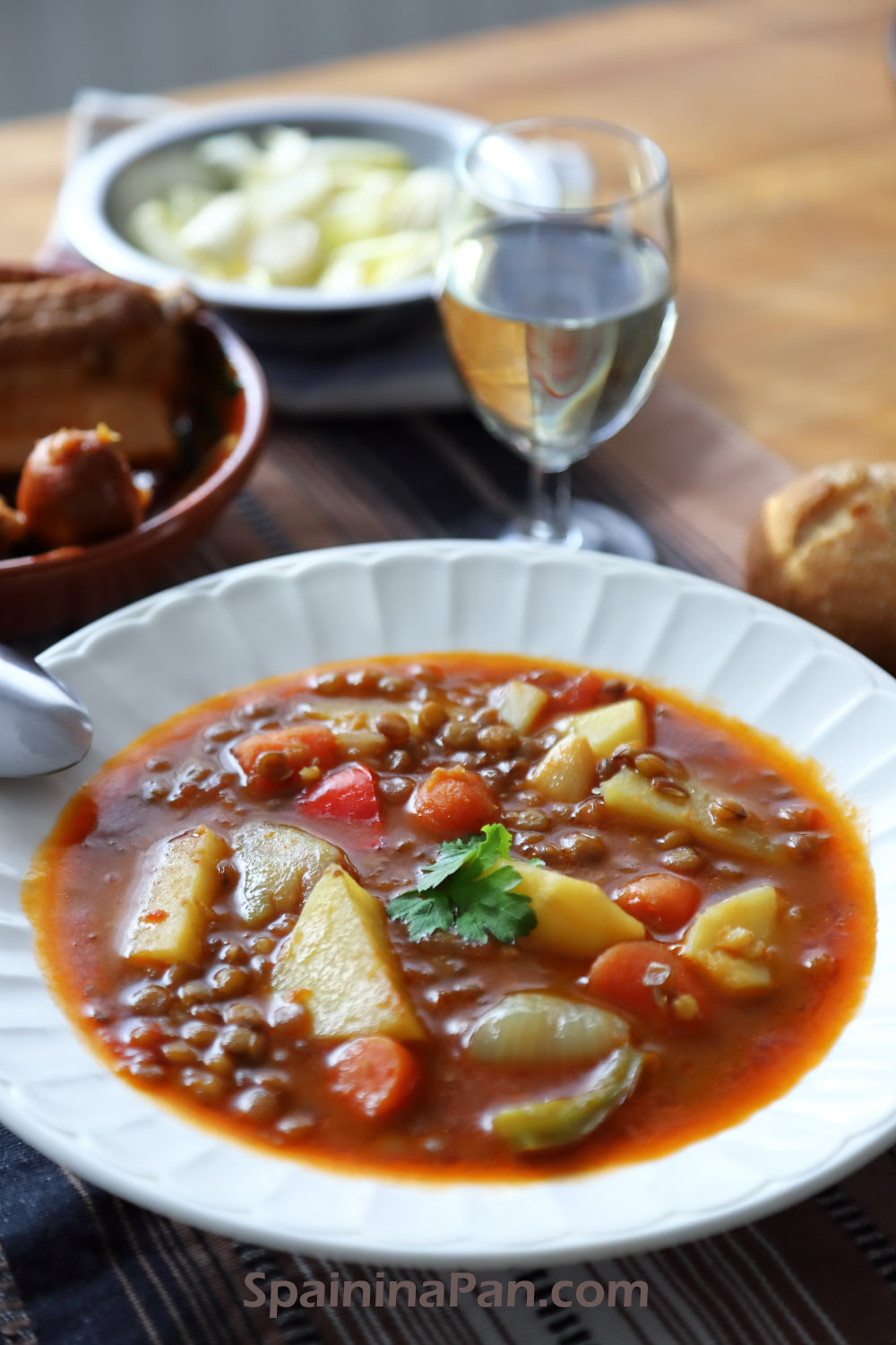 An appetizing Spanish lentil sou with potatoes and carrots in a soup dish.