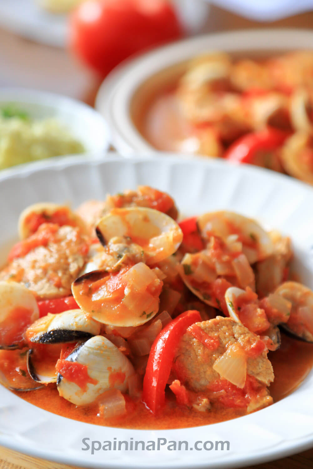 Spanish pork loin with venus clams stew on a plate.