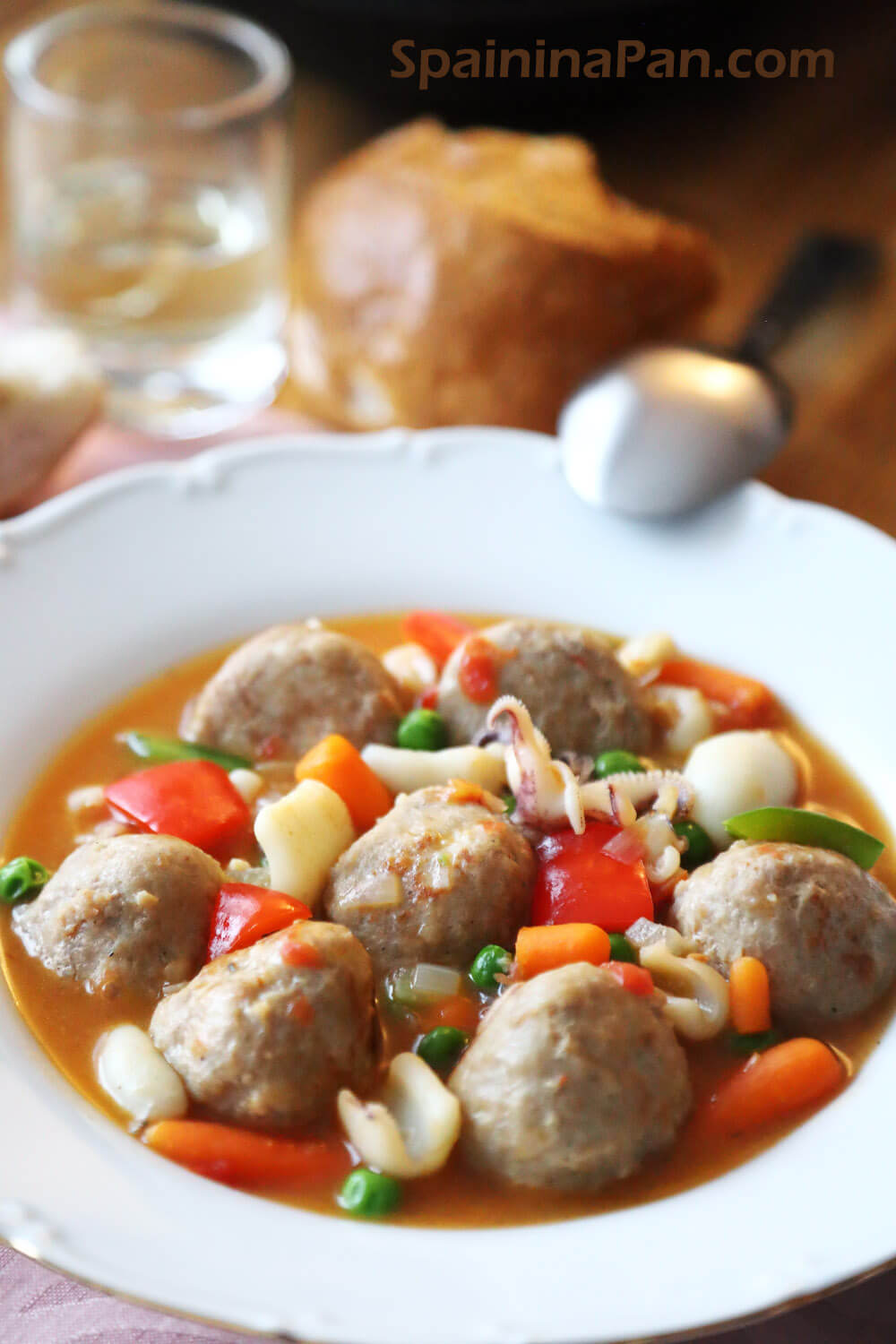 Spanish meatballs with sepia cuttlefish stew in a white plate.