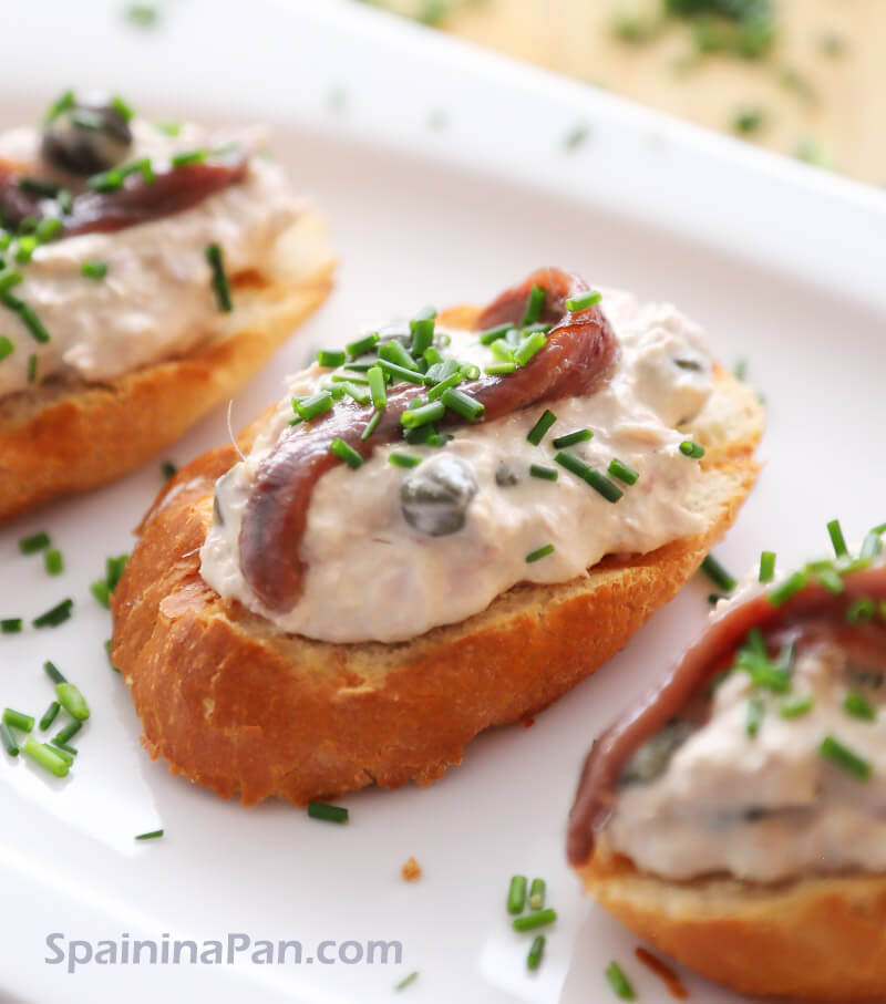 Spanish montadito toast with tuna and anchovy on a plate.