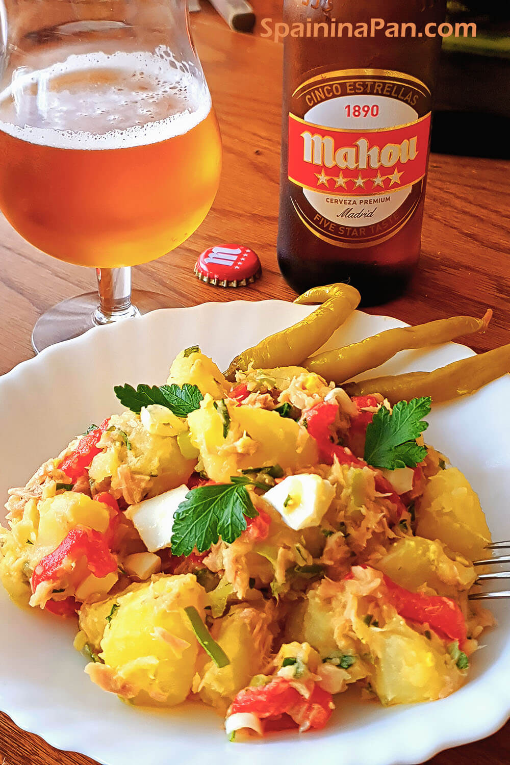 Fresh Spanish patatas aliñadas salad on a plate with beer.