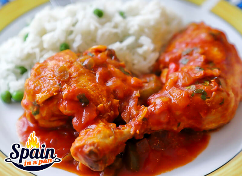 Spanish pollo al chilindron chicken with white rice on a plate.