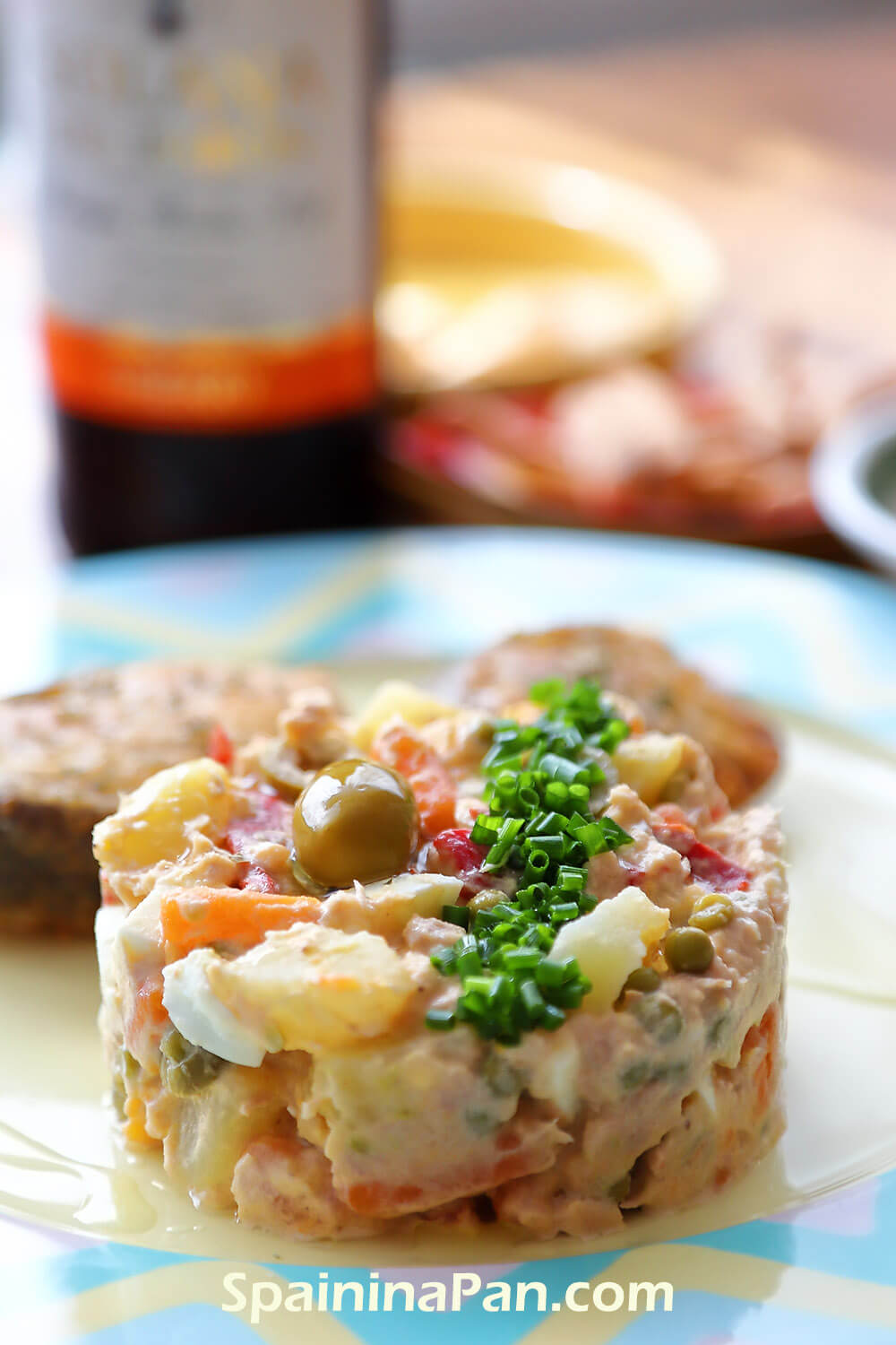 Spanish potato salad with hake on a stylish plate.