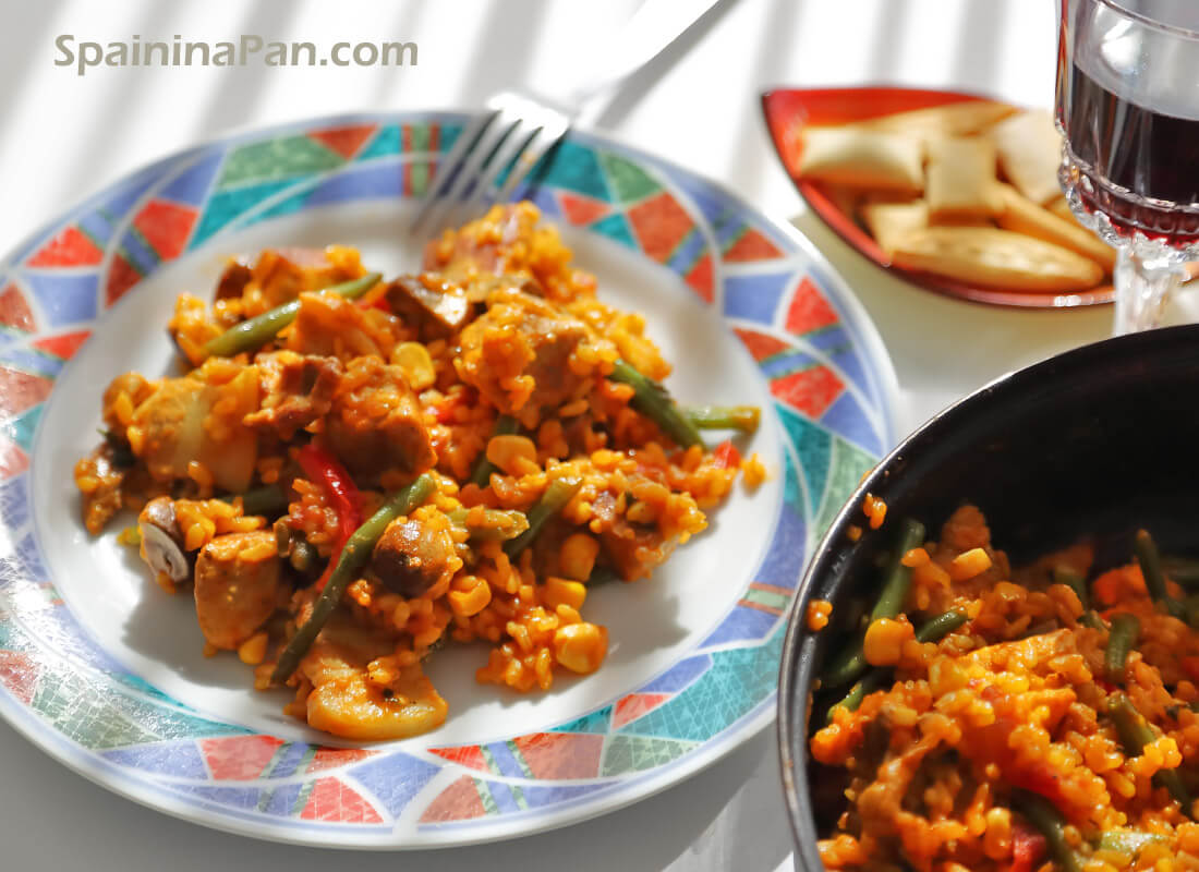 Spanish rice with pork belly on a decorative plate. Spanish rice with pork belly on a decorative plate.