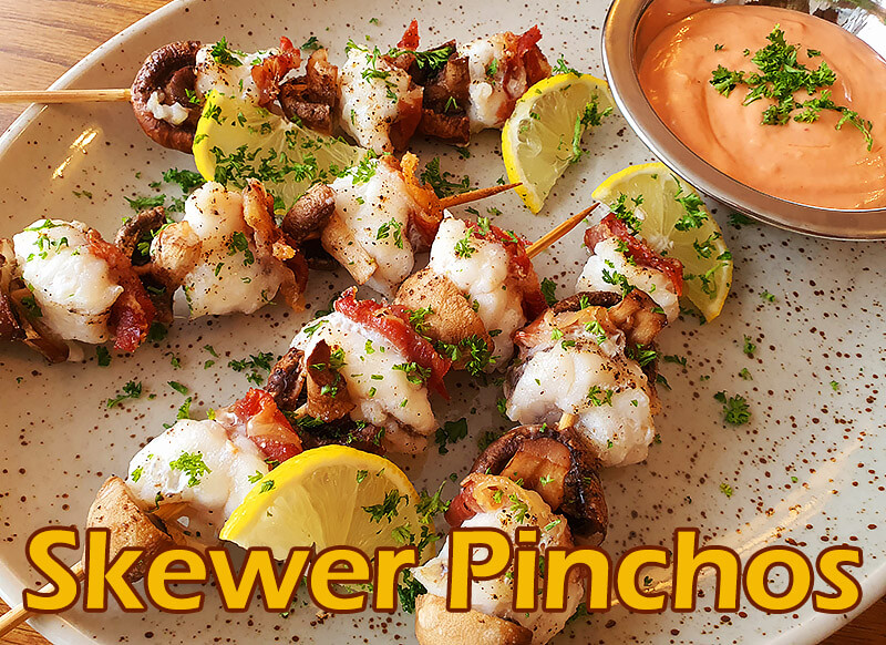 Spanish skewer pinchos with cocktail sauce on a plate. on