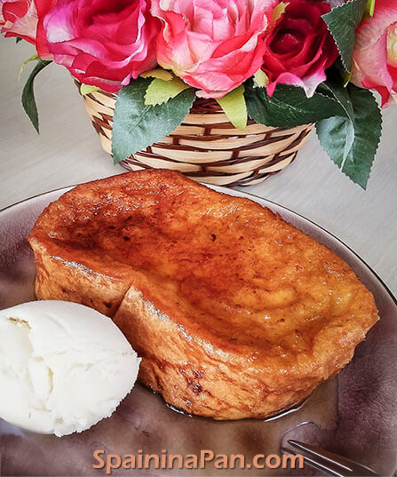 Spanish honey torrija served with a scoop of ice cream on a plate.