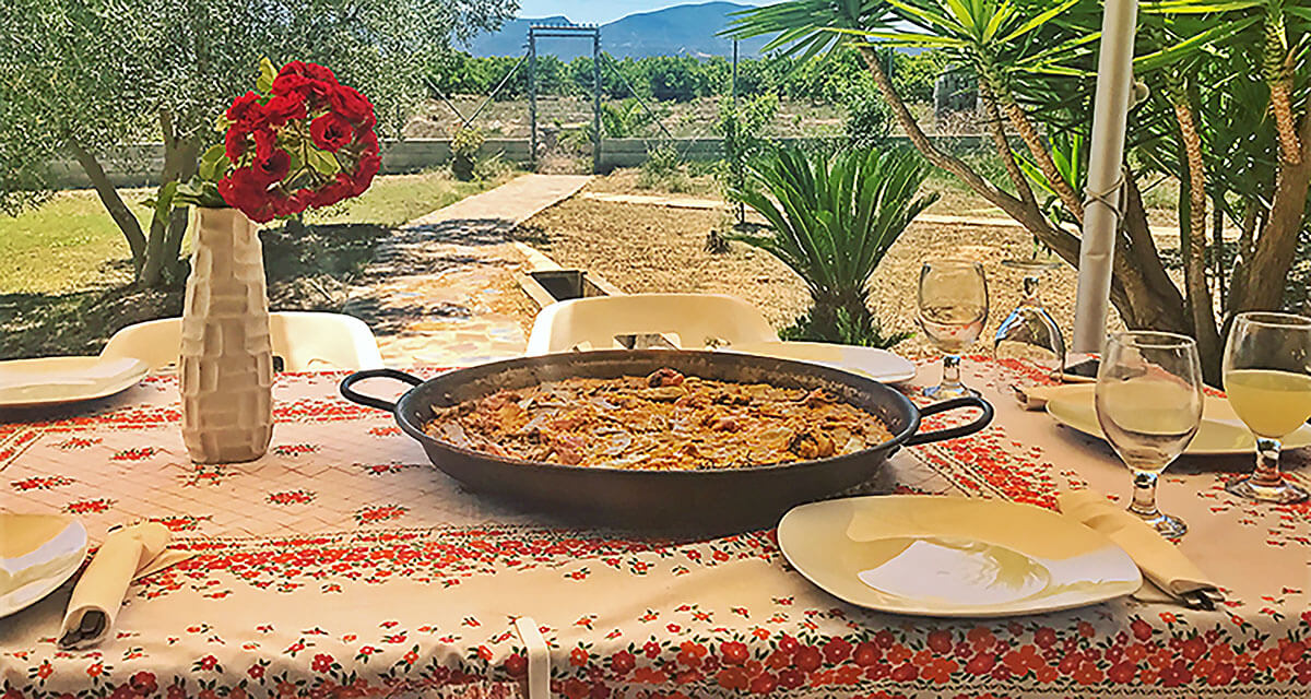 Table with paella outside in the garden Table with paella outside in the garden