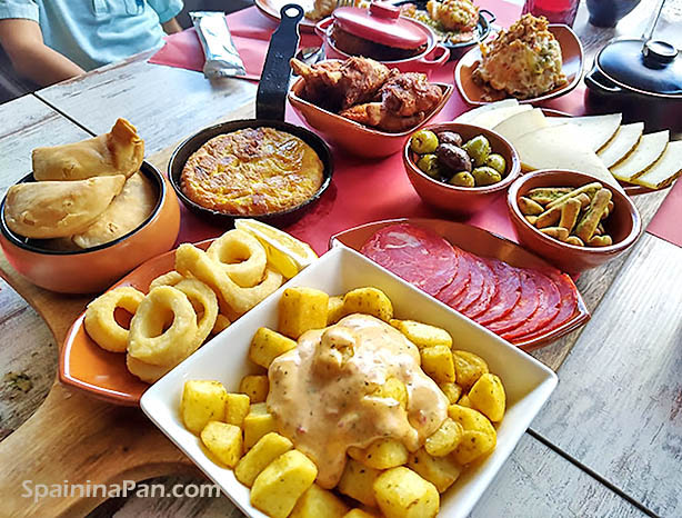 A variety of tapas dishes and coldcuts on a table
