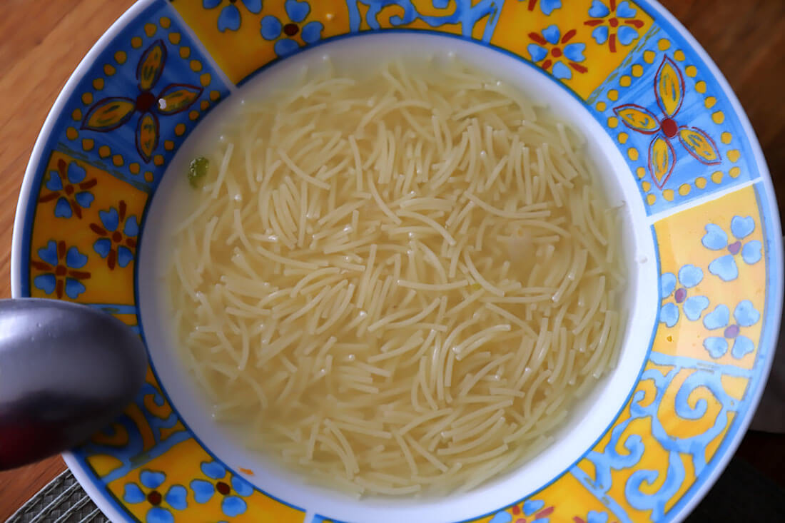 Vermicelli soup in a bowl from a Madrilenian cocido stew.